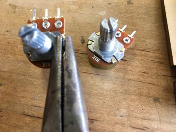Remove the small metal keying tab from each potentiometer with a pair of pliers, so that they can be mounted flush to the panel without adding