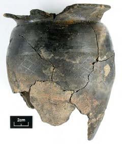 The lower body is severely burnt and the surface has deteriorated and spalled. Such damage is typical of cremation urns which have been put on the cremation pyre before burial.
