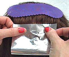 13. With your thumb and finger against the foil, fold the foil toward the scalp in half; fold left side over to the center, then the right side or use the wiretail to crease the foil and bend it