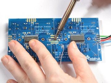 Use your soldering iron to drag solder from one pad to another, with a little effort they'll stick