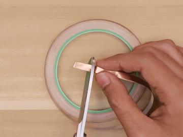 do this. This copper tape has a sticky adhesive backing that is conductive, so we can stick it to our touch pads. Cut five short pieces using scissors.