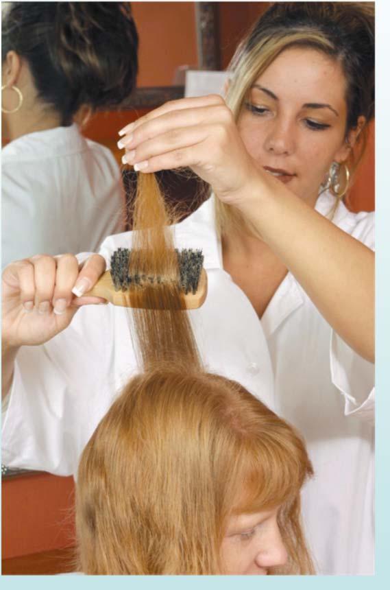 BRUSHING THE HAIR Make center part from front to nape. Section half an inch off center to the crown of head. Hold strand of hair in nondominant hand between thumb and fingers.