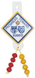 A boy earns totem beads by working on the five Tiger Cub achievements. IMMEDIATE RECOGNITION PATCH (and Beads) Blue, white, and yellow Cub Scout diamond with the words, "Progress Toward Ranks.