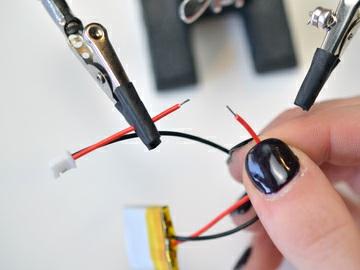 Add two small pieces of heat shrink tubing to the stripped wires and solder to two legs of the small switch