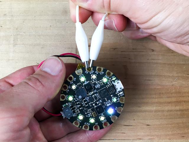 Plug in your battery, make sure the slide switch is set to the left, and then squeeze the wire while holding the board in order to trip the sensor and change colors.
