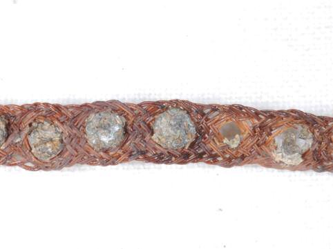 13 Wrist/arm band The carefully woven strands of fibre used to craft this delicate band are made from cow hair. The circular domed rivets placed at regular intervals along it are made from tin.