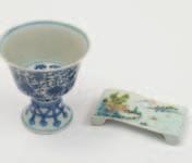 400-600 559 A Chinese blue and white stem-cup with flared rim and splayed foot, painted with symbols surrounded by flowering and scrolling lotus, horizontal six-character Qianlong mark and of the