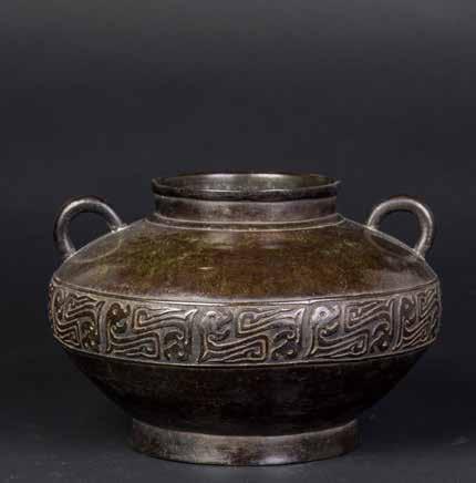 1009 十九世纪铜兽面纹活环耳尊 A CHINESE BRONZE ZUN VASE A Chinese bronze vase. A round base supports a thick lower body adorned with eight decorative heraldic shield panel carvings.