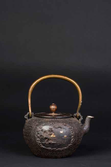 1028 大正期斧师造紫铜斑盖助纹铁壶 A JAPANESS TETSUBIN CAST IRON TEAPOT A Taisho period traditional Tetsubin Japanese cast iron teapot. The body of the pot displays a mottled effect and is un-patterned.