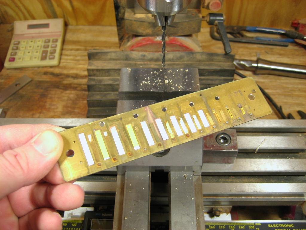 Next the five nail holes along the back of the reedplate are opened up with a 3/32 drill bit.