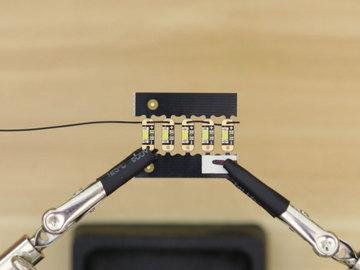 We used tweezers to easily maneuver the wires through each hole. Start by looping the wires from the bottom of the PCB to the top of the next.