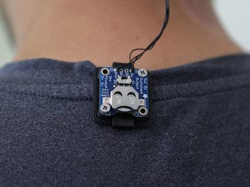 Clip on Position the board so the wires are facing towards the top of your shirt.