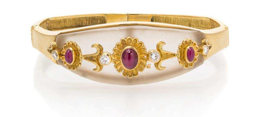 Lot 276 An 18 Karat Yellow Gold, Rock Crystal, Ruby and Diamond Bangle, Lalaounis, consisting of a navette shape frosted rock crystal plaque surmounted with gold florettes and scrolled accents