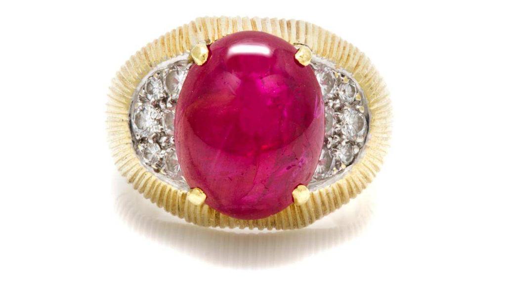 Trio Lot 136 An 18 Karat Yellow Gold, Ruby and Diamond Ring, Trio, containing one oval shape cabochon cut ruby measuring approximately 12.82 x 10.22 x 5.