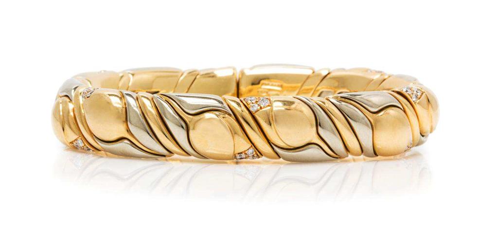 Lot 397 An 18 Karat Two Tone Gold and Diamond "Tulip" Cuff Bracelet, Bulgari, consisting of sculpted white and yellow gold sections arranged around a flexible base, accents at regular intervals
