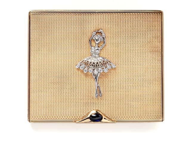 324 324 Retro 14kt Gold Compact, Van Cleef & Arpels, New York, the line-engraved case with platinum and diamond ballerina, cabochon sapphire pushpiece, opening to a mirrored compartment, 78.
