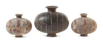 Greiner Trust, Rockford, Illinois 3* Three Pottery Cocoon Jars HAN DYNASTY each having a well-potted body raised on a short spreading foot, the irst a black pottery example painted with white ribs,