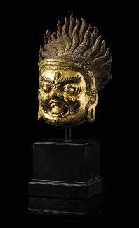 $5,000-7,000 585 A Sino-Tibetan Gilt Bronze Head of Bodhisattva Mahakala 18TH/19TH CENTURY the rounded face cast with a ierce expression, a pair of bulging eyes between