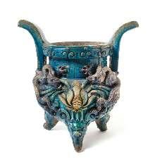94 92 92* A Large Turquoise Glazed Pottery Censer MING DYNASTY having a globular body applied with sinuous dragons lanking a blooming lotus, having two upright handles and raised on three mask feet.