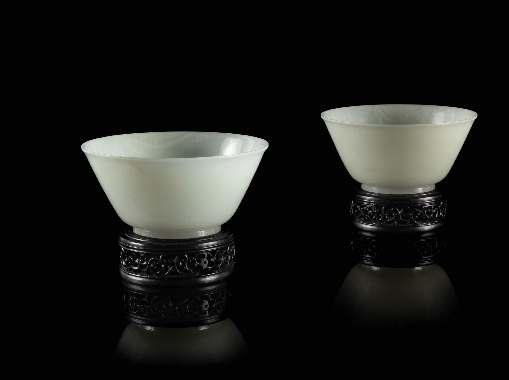 291 291* A Pair of Fine White Jade Bowls 18TH/EARLY 19TH CENTURY each of a well-polished semi-translucent stone with white mottling, inely carved with deep rounded walls rising from a short straight