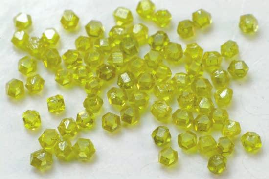 3-11: Synthetic diamonds with cubo-octahedral habit, exhibiting the characteristic yellow color of pure Type Ib diamonds, which is caused by single-substitutional nitrogen impurities.