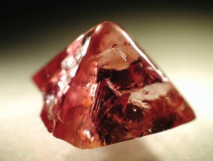 3-26: One half of a slightly rounded octahedral diamond with a reddishpink color (2.67 ct). Argyle mine, Western Australia.