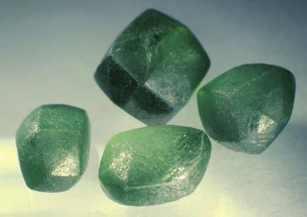 3-27: Dodecahedral diamonds with intense green surface colors give the impression of a green body color (0.35 0.50 ct).