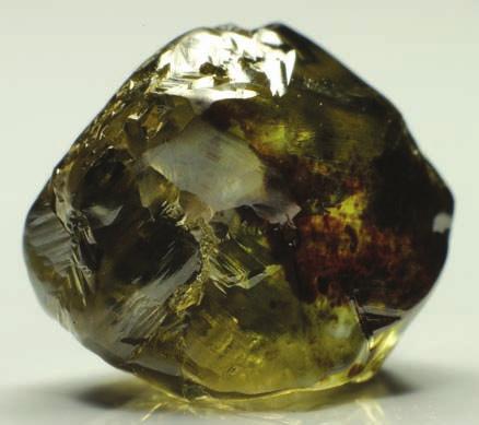 3-38: Distorted dodecahedral diamond with a homogeneous green surface skin and additional green and brown surface spots (1.62 ct). Bow River, Western Australia.