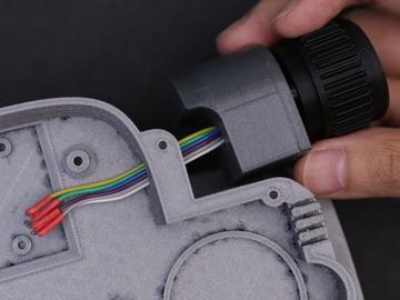 Thread the angled jumper cable connectors through the hole on the side of the base-main part.