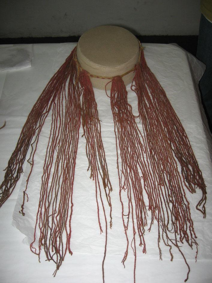 Object L: Headband with long red tassels Accession #: 130-02-01 Principle cord 111 cm long x 4-6 mm