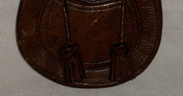 I chose to stitch it as a flat seam with the edges showing and then carefully cover the rough edges of the leather with a thin strip of leather similar to what was done at the