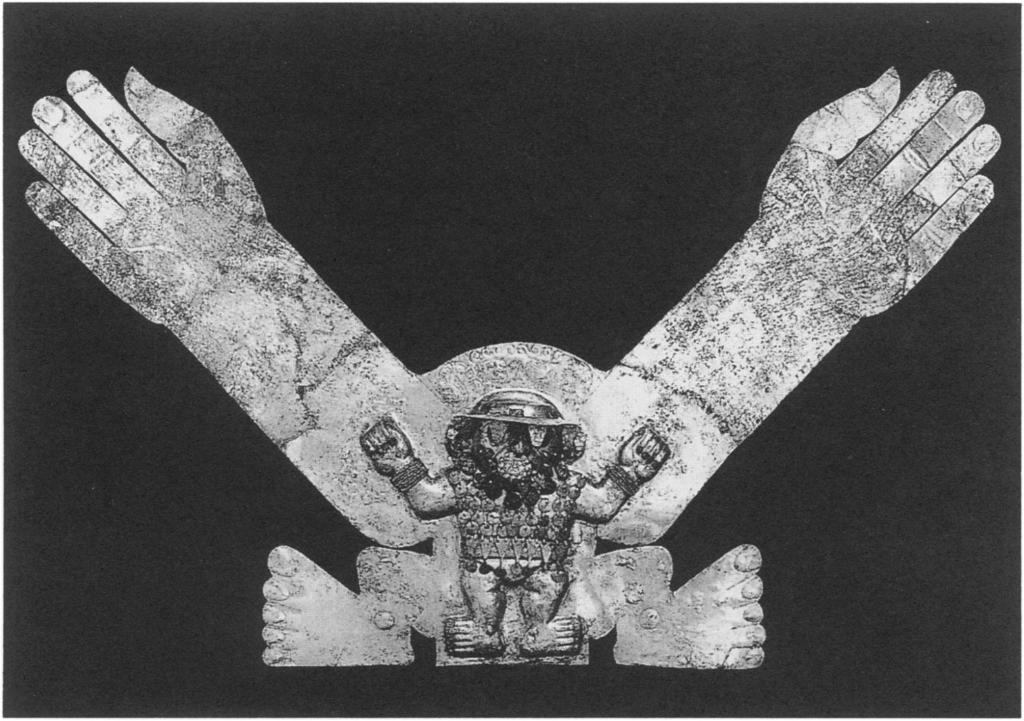 Figure 21. "Headless figure" ornament, Moche, from Sipan, Peru. Gilded-copper sheet and silver, H. 42.5 cm. The sheet is gilded copper and the finger and toenails are inlaid with silver.
