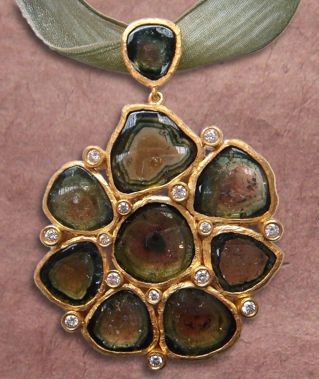 5 in (6 x 4 cm) A stunning handmade multicolor tourmaline pendant in 24k yellow gold framed with diamonds. This unique piece comes with a matching green silk ribbon.