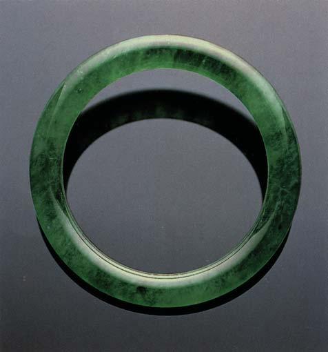 Traditionally, when fine jadeite cabochons are mounted in jewelry, they are backed by metal with a small hole in the center.