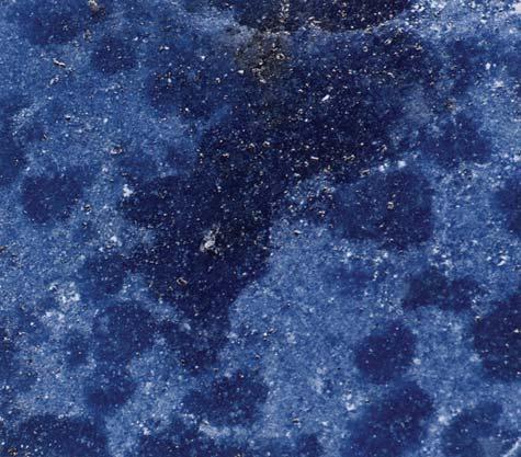 The less lazurite there is, the lighter the overall appearance of the lapis lazuli will be (right; photomicrograph by John I. Koivula, magnified 20 ).