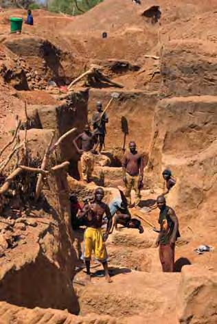 Working in small groups, they use picks and shovels to dig through the laterite overburden in search of the gem-bearing layer. Photo by B. M. Laurs. Figure 13.