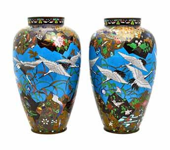 A pair of Japanese cloisonné vases, Meiji period, of slender ovoid form, each worked with a blue-ground central frieze depicting birds in flight above convolvulus, between elaborate panelled borders