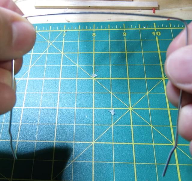 Using the needle nose pliers, put a single bend in the center of the wire.