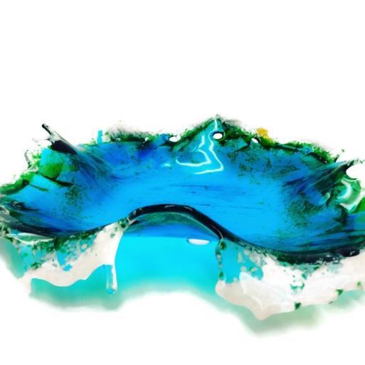 This one of a kind glass sculptural oceans splash bowl is the perfect piece of home décor for ocean and beach lovers. The beautiful transparent colors seem to glow when the light hits the glass.