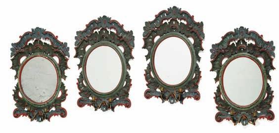 160 160 a set of four north German green and red painted oval mirrors, each carved with c-scrolls, openwork rocailles and two brass bracket arms.