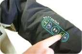Soft switch built into the sleeve of a jacket uses QTC to control an MP3 player in the wearers inside pocket.