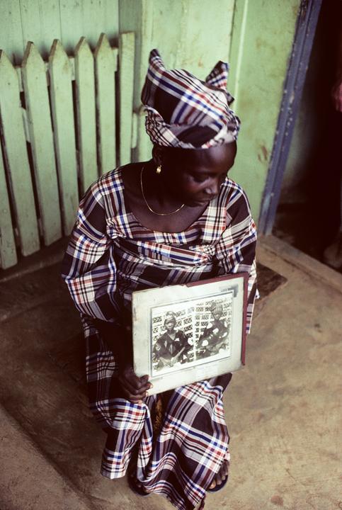 Fig. 1. Marilyn Houlberg, Twin girl (survivor, holding double exposure photograph representing herself and her deceased twin brother). Ila Orangun, Nigeria. 1983.