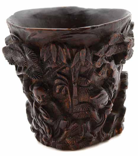 Works of Art 6071 An Aloeswood Wine Cup 18th Century The irregular slightly conical form carved in high relief with three figures relaxing and engaging in leisurely