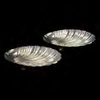 473 Pair of Sterling Flower Dishes. Each sterling dish an oval with flower center and lobed petals, resting on two ball feet.