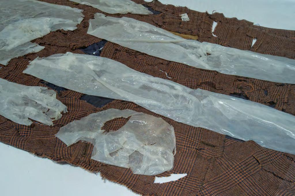 An integral cast of the artist's body made with dried glue lying on a sheet made by cutting and re-sewing a dress by Valentino, used in the video-performance Reads Valerie Solanas.