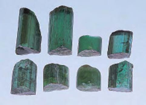 Figure 23. Heating experiments were conducted on the bottom portions of these four crystals of DRC tourmaline, while the top untreated portions were retained for comparison.