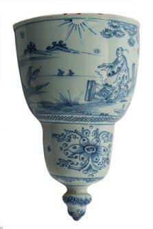554 A London blue and white delftware wall pocket of D form with slightly concave back, painted with a Chinese figure standing behind a fence on the side of a lake, a man in a boat beyond, the lower