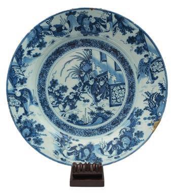 560 A German blue and white fayence twohandled spiced wine bowl and cover: with small internal strainer, painted overall with Chinese figures in garden landscapes, probably Frankfurt, early 18th