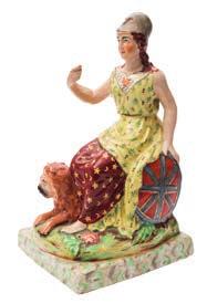 * 80-120 573 A Staffordshire pearlware equestrian figure in the form of a lady wearing a feather plumed hat and blue jacket riding side saddle, on green tree