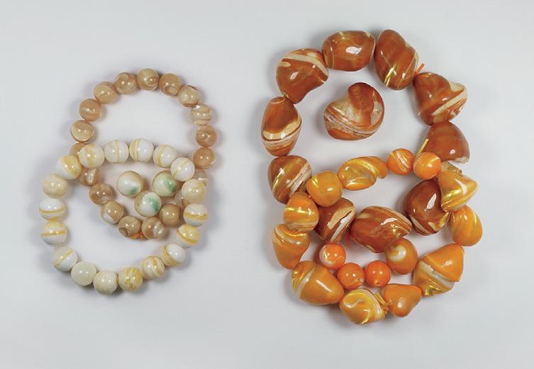Figure 28. The Golden Tridacna beads on the left (7 8 mm in diameter), some with green patches, were fashioned from naturally colored conch shell.